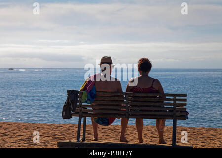 Älteres Paar beim Sitzen am Meer auf der Suche nach einem Tag am Strand Stockfoto