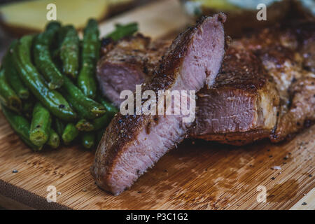 Gegrilltes Schweinefleisch Hals Steak und grünen Bohnen und gebackene Kartoffeln Stockfoto