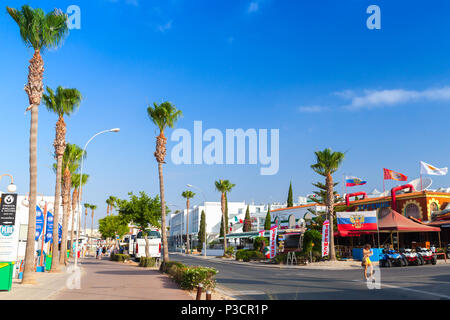 Ayia Napa, Zypern - 11. Juni 2018: Agia Napa Stadt an der Südküste von Zypern Island, Street View am Sommer, der Tag. Touristen zu Fuß auf der Straße Stockfoto