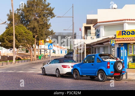 Ayia Napa, Zypern - 11. Juni 2018: Street View mit parkenden Autos. Agia Napa Stadt an der Südküste von Zypern Insel im Sommer Abend Stockfoto
