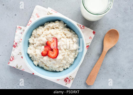 Haferflocken Porridge mit Erdbeeren Ansicht von oben. Brei Hafer in blauer Schüssel. Ansicht von oben gesundes Frühstück Stockfoto