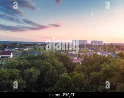 Eine Ansicht aus der Luft in den Wald, Häuser und Felder des Dorfes. Einen warmen Mai Sonnenuntergang. Stockfoto