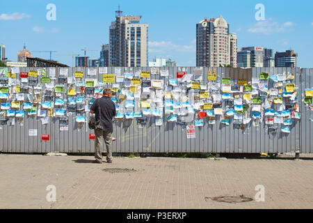 Bulletin Board auf den Metallzaun mit bunten Meldungen auf der Straße Stockfoto