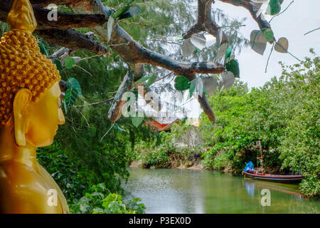 Ein Buddha Statue mit Blick auf einen Stream neben einem Kloster in Koh phangan, Thailand Stockfoto