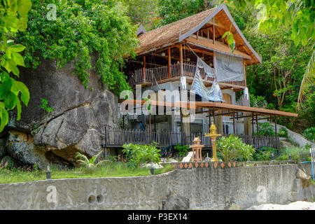 Thai Geist Haus neben Ruinen der ein Hotel am Strand von Koh Phangan, Thailand. Ein Geist Haus ist ein Schrein der schützenden Geist des Ortes, die Stockfoto