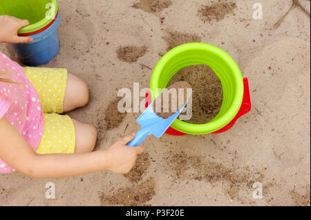 Kind, Spaß, Sandbox, Spielzeug, Freude, lernen, Schaufel, Eimer, bunt, Tag, sonnig, Fantasie, Spaß, Unterhaltung, gewaltfreie Kommunikation Stockfoto