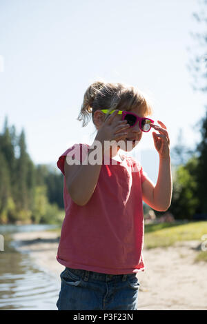 Süße Mädchen tragen Sonnenbrillen in der Nähe von River Bank Stockfoto