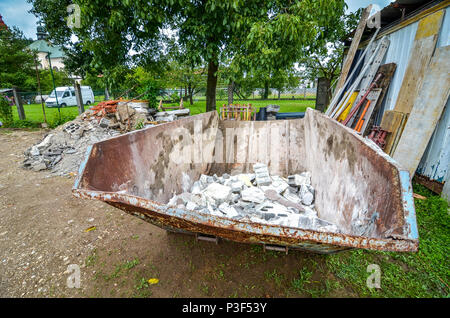 Bau Abfallbehälter Müllcontainer am Wohnhaus Baustelle. Abfallwirtschaft im Baugewerbe und eine Baustelle. Stockfoto