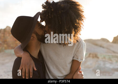 Paar küssen einander am Strand Stockfoto