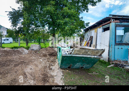 Bau Abfallbehälter Müllcontainer am Wohnhaus Baustelle. Abfallwirtschaft im Baugewerbe und eine Baustelle. Stockfoto