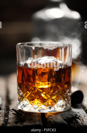 Zigarre und Glas mit Whiskey mit Eiswürfel Stockfoto