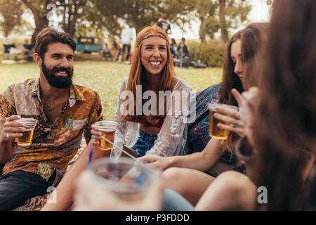 Junge Hippie Freunde feiern im Park mit Bier. Eine Gruppe von Freunden eine Party im Music Festival im Park. Stockfoto