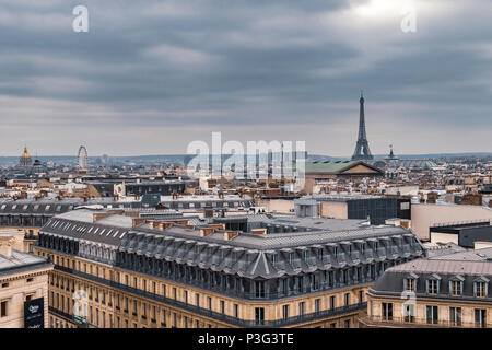Der Eiffelturm und die eleganten grauen Schiefer Dächer von Paris Apartment Gebäuden ein laufender Balkon und Zimmer im Dachgeschoss, Boulevard Haussmann, Paris, Frankreich Stockfoto