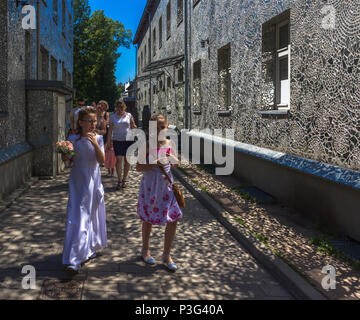 Familie in Rosa's Passage, Łódź, Polen - ein Mosaik aus kleinen, unregelmäßigen Stücken des Spiegels an den Fassaden der Häuser Stockfoto