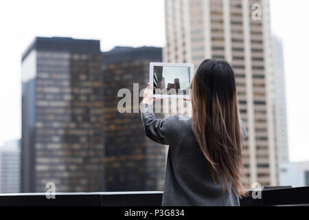 Geschäftsfrau Wolkenkratzer Fotografieren mit Ihrem Tablet Stockfoto