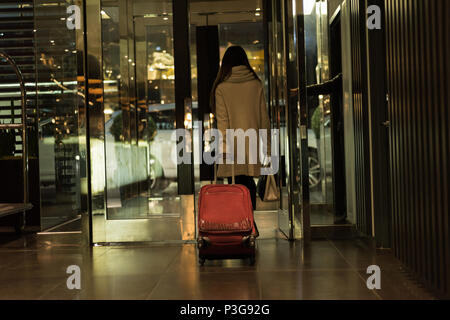 Geschäftsfrau zu Fuß aus dem Hotel Zimmer mit Gepäck Stockfoto