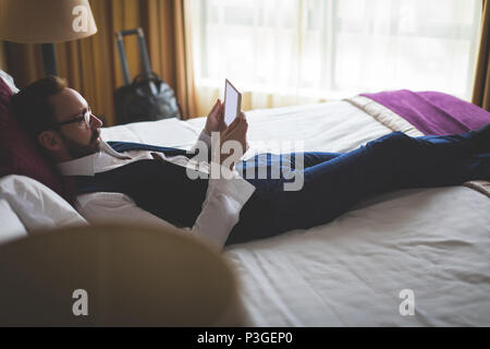 Geschäftsmann mit digitalen Tablet im Schlafzimmer Stockfoto