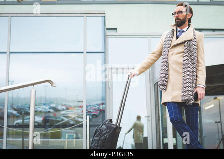 Unternehmer stehen mit Trolley Tasche Stockfoto