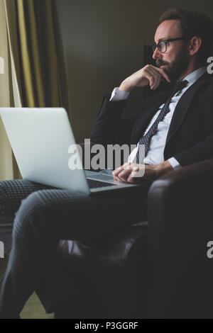 Geschäftsmann mit Laptop im Hotelzimmer Stockfoto