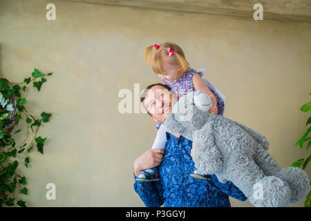 Portrait von lustigen, kleinen Mädchen und ihrem Vater zu Hause. Familie, Kindheit und Freizeit Konzept Stockfoto