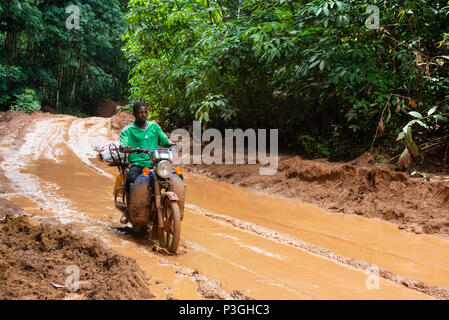 Motorrad auf einen schlammigen Protokollierung Straße in der Nähe von Kribi in Kamerun Stockfoto