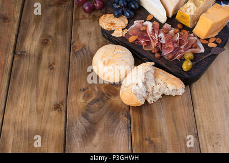 Snack zu Wein. Frisch gebackenes Brot. Verschiedene Snack für Wein. Käse, Oliven, Trauben Platz kopieren. Flach. Stockfoto