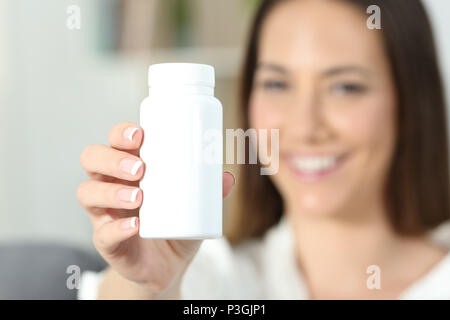 In der Nähe von eine glückliche Frau Hand zeigt eine leere Medizin Flasche Pillen Stockfoto