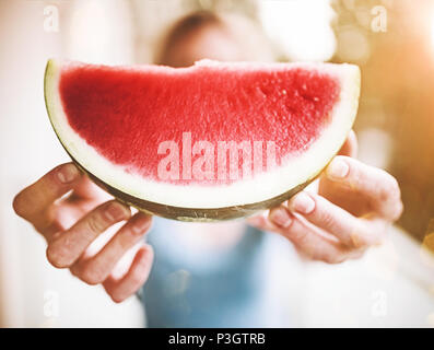 Blonde Frau hält ein Stück saftige frische Wassermelone Stockfoto