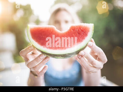 Blonde Frau hält ein Stück saftige frische Wassermelone Stockfoto