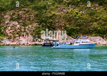 Entspannende Boote ankern in der Nähe von kleinen Inseln. Eine Gruppe von Personen unkenntlich Spaß Aktivitäten auf Ferien Urlaub Meer Reise. Stockfoto