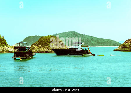 Entspannende Boote ankern in der Nähe von kleinen Inseln. Eine Gruppe von Personen unkenntlich Spaß Aktivitäten auf Ferien Urlaub Meer Reise. Stockfoto