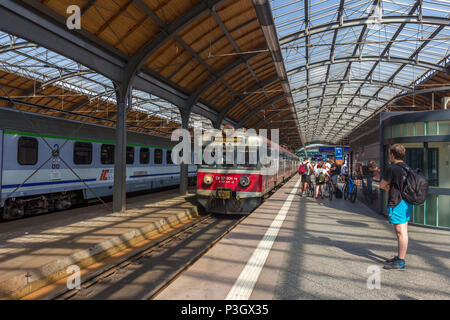 Junger Mann wartet auf Plattform mit Rucksack im Zug bei Wrocław Główny - Breslauer Hauptbahnhof ankommt Stockfoto