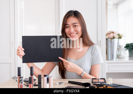 Asiatische junge weibliche blogger Werbegeschenk Geschenk fan folgenden Kanal während der Aufnahme vlog Video mit Make-up Kosmetik zu Hause online Einflussnehmer Konzept. live Stockfoto