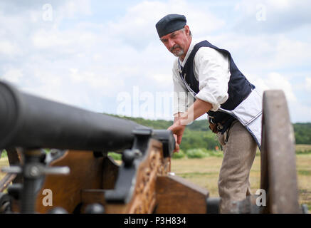 16 Juni 2018, Deutschland, Sondershausen: Jonathan Hannaford Reinigung der Kanone während des 4. Europäischen Meisterschaft der Light Field Artillery. Während des Wettbewerbs, Maulkorb- laden Kanonen mit einem Kaliber zwischen 51 und 90 mm werden erschossen, während in historischen Kostümen gekleidet, an den Zielen 100 oder 200 Meter entfernt. Foto: Britta Pedersen/dpa Stockfoto