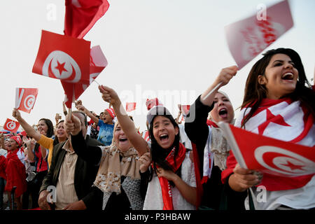 Tunis, Tunesien. 18 Juni, 2018. Tunesischen Fußball Fans jubeln für die Mannschaft, wenn sie die 2018 FIFA World Cup Match zwischen Tunesien und England auf einem großen Bildschirm in Tunis, der Hauptstadt von Tunesien beobachtet, am 18. Juni 2018. Credit: Adele Ezzine/Xinhua/Alamy leben Nachrichten Stockfoto