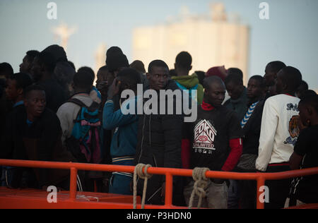 Hafen von Malaga, Spanien. 18 Juni, 2018. Migranten, die von einem Beiboot im Mittelmeer gerettet wurden, stehen an Bord auf ein Rettungsboot nach ihrer Ankunft am Hafen von Malaga. Mitglieder der Spanischen Sicherheit auf See gerettet Insgesamt 166 Migranten in der Nähe der Küste von Malaga an Bord vier Jollen und brachte am Hafen von Malaga, wo sie durch das Spanische Rote Kreuz unterstützt wurden. Credit: SOPA Images Limited/Alamy leben Nachrichten Stockfoto