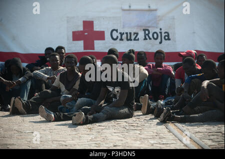 Hafen von Malaga, Spanien. 18 Juni, 2018. Migranten, die von einem Beiboot im Mittelmeer gerettet wurden, warten auf den Boden nach ihrer Ankunft am Hafen von Malaga. Mitglieder der Spanischen Sicherheit auf See gerettet Insgesamt 166 Migranten in der Nähe der Küste von Malaga an Bord vier Jollen und brachte am Hafen von Malaga, wo sie durch das Spanische Rote Kreuz unterstützt wurden. Credit: SOPA Images Limited/Alamy leben Nachrichten Stockfoto