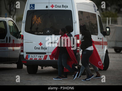 Hafen von Malaga, Spanien. 18 Juni, 2018. Migranten, die von einem Beiboot im Mittelmeer gerettet wurden, gehen neben einem Krankenwagen nach ihrer Ankunft am Hafen von Malaga. Mitglieder der Spanischen Sicherheit auf See gerettet Insgesamt 166 Migranten in der Nähe der Küste von Malaga an Bord vier Jollen und brachte am Hafen von Malaga, wo sie durch das Spanische Rote Kreuz unterstützt wurden. Credit: SOPA Images Limited/Alamy leben Nachrichten Stockfoto