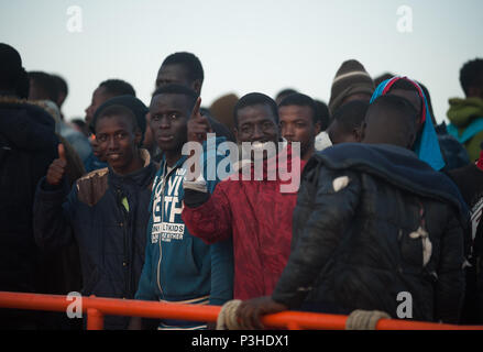 Malaga, Spanien. 18 Juni, 2018. Migranten, die von einem Beiboot im Mittelmeer gerettet wurden, Gesten zu einem Rettungsboot nach ihrer Ankunft am Hafen von Malaga. Mitglieder der Spanischen Sicherheit auf See gerettet Insgesamt 166 Migranten in der Nähe der Küste von Malaga an Bord vier Jollen und brachte am Hafen von Malaga, wo sie durch das Spanische Rote Kreuz unterstützt wurden. Credit: Jesus Merida/SOPA Images/ZUMA Draht/Alamy leben Nachrichten Stockfoto