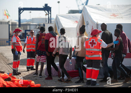 Malaga, Spanien. 18 Juni, 2018. Migranten, die von einem Beiboot im Mittelmeer gerettet wurden, werden von den Mitgliedern des spanischen Roten Kreuzes nach ihrer Ankunft am Hafen von Malaga geholfen. Mitglieder der Spanischen Sicherheit auf See gerettet Insgesamt 166 Migranten in der Nähe der Küste von Malaga an Bord vier Jollen und brachte am Hafen von Malaga, wo sie durch das Spanische Rote Kreuz unterstützt wurden. Credit: Jesus Merida/SOPA Images/ZUMA Draht/Alamy leben Nachrichten Stockfoto