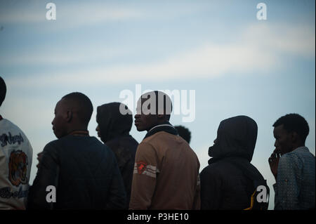 Malaga, Spanien. 18 Juni, 2018. Ein Migrant, der von einem Beiboot im Mittelmeer gerettet wurde, blickt auf ein Rettungsboot nach seiner Ankunft am Hafen von Malaga. Mitglieder der Spanischen Sicherheit auf See gerettet Insgesamt 166 Migranten in der Nähe der Küste von Malaga an Bord vier Jollen und brachte am Hafen von Malaga, wo sie durch das Spanische Rote Kreuz unterstützt wurden. Credit: Jesus Merida/SOPA Images/ZUMA Draht/Alamy leben Nachrichten Stockfoto