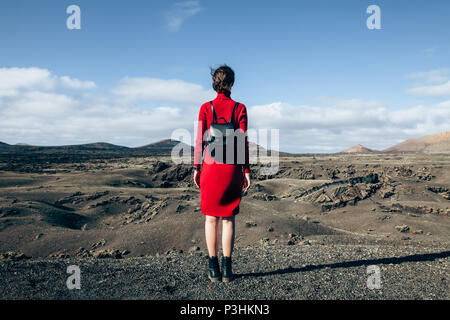 Rückansicht des reisenden Frau genießen einzigartige vulkanische Landschaften der Nationalpark Timanfaya auf Lanzarote, Kanarische Insel. Reisen und Ferien Konzept Stockfoto