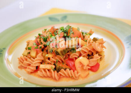 Fusilli gekleidet mit Tomaten, Zucchini, Auberginen und Paprika. Pasta mit Gemüse, bereit zu essen. Stockfoto