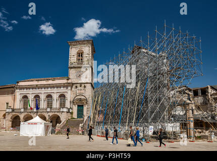 Palazzo Comunale, beschädigt und Fassade, die von Gerüsten, der Basilika unterstützt, von Erdbeben zerstört, April 2018, in Norcia, Umbrien, Italien Stockfoto