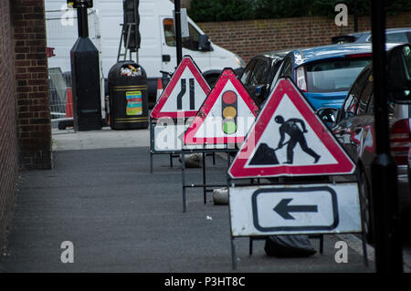 Männer an der Arbeit, Ampel und Straße verengt Baustelle Zeichen in Stoke Newington, Hackney, London Stockfoto