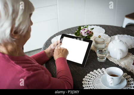 Ältere Frau mit Tablet-PC im Wohnzimmer Stockfoto