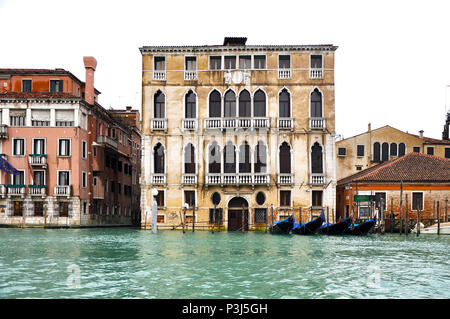 Pastellfarbenen Gotischen venezianischen Gebäude auf dem Canal Grande mit einer Reihe der angedockten blau Gondeln, Venedig, Italien. Stockfoto