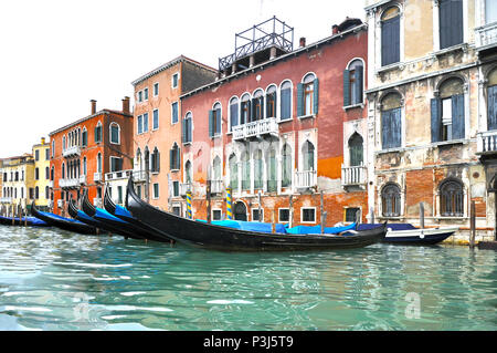 Reihe von bunten gotischen Gebäude am Großen Kanal mit einer Reihe von angedockt blau Gondeln, Venedig, Italien. Stockfoto