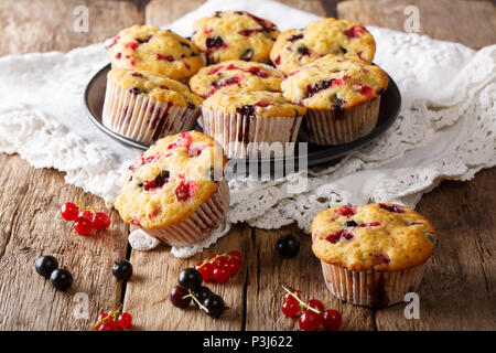 Hausgemachten Dessert: Muffins mit Beeren Mix von Korinthen close-up auf einem Teller auf dem Tisch. Horizontale Stockfoto