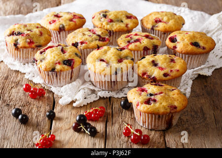 Frisch gebackene Muffins mit schwarzen und roten Johannisbeeren Beeren close-up auf dem Tisch. Horizontale Stockfoto